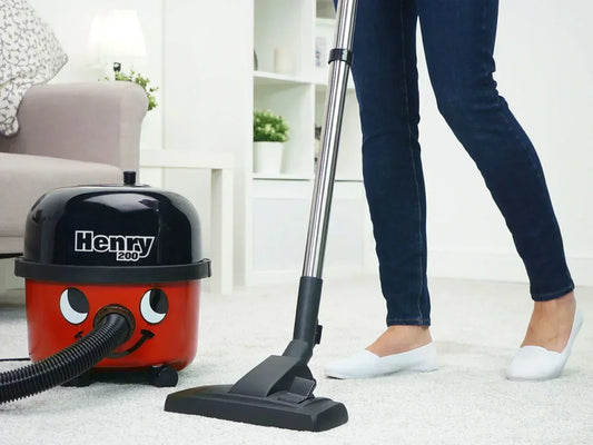Henry 200 canister vacuum cleaning a light-coloured rug in a living room