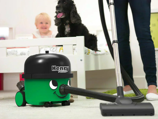 A person using Henry PetCare on the floor with a dog and baby in the background