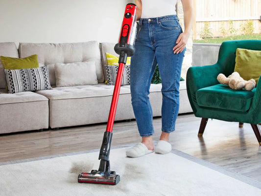 Woman using a stick vacuum to clean