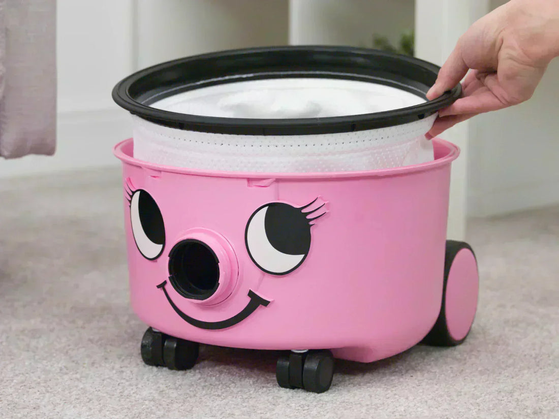 A hand pulling a dust bag out of a Henry Hetty 200 bagged vacuum